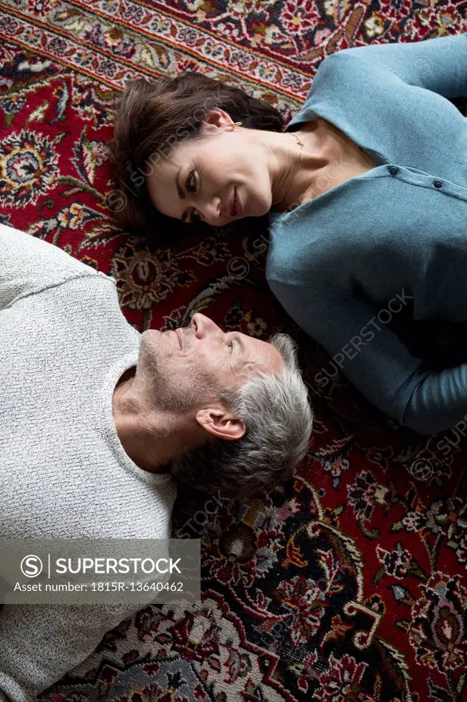 Mature couple lying on carpet