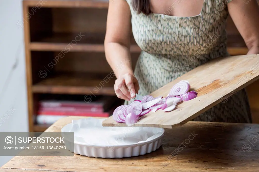 Woman preparing red onions for onion pesto
