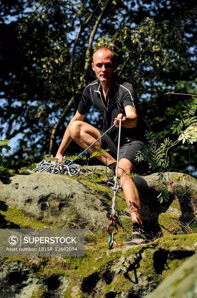 Climber crouching on a rock