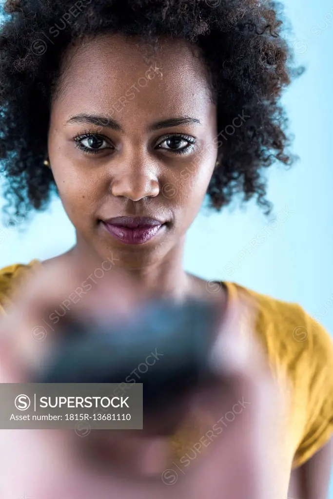 Portrait of young woman with remote control