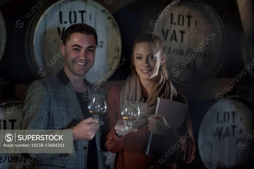 Portrait of smiling man and woman tasting wine