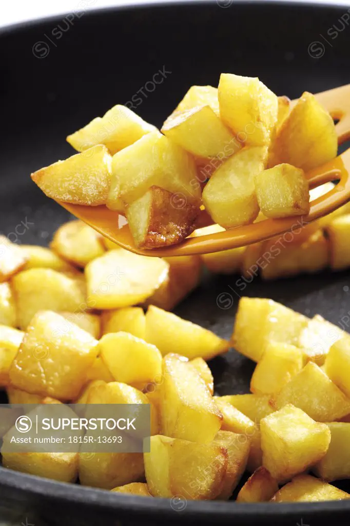 Fried potatoes on spatula, close-up