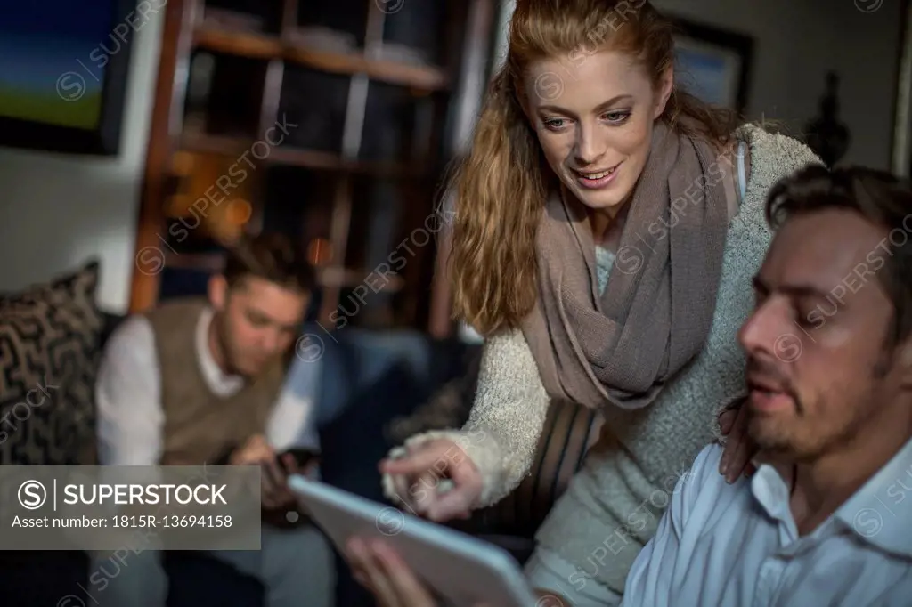 Woman talking to man using tablet