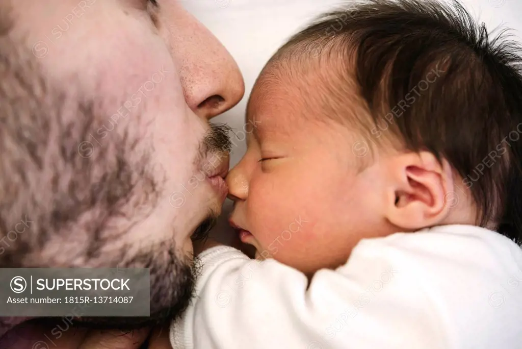 Father kissing his newborn baby girl