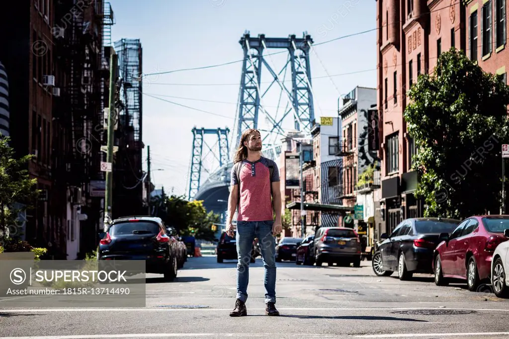 USA, New York City, man standing on the street looking around in Williamsburg, Brooklyn