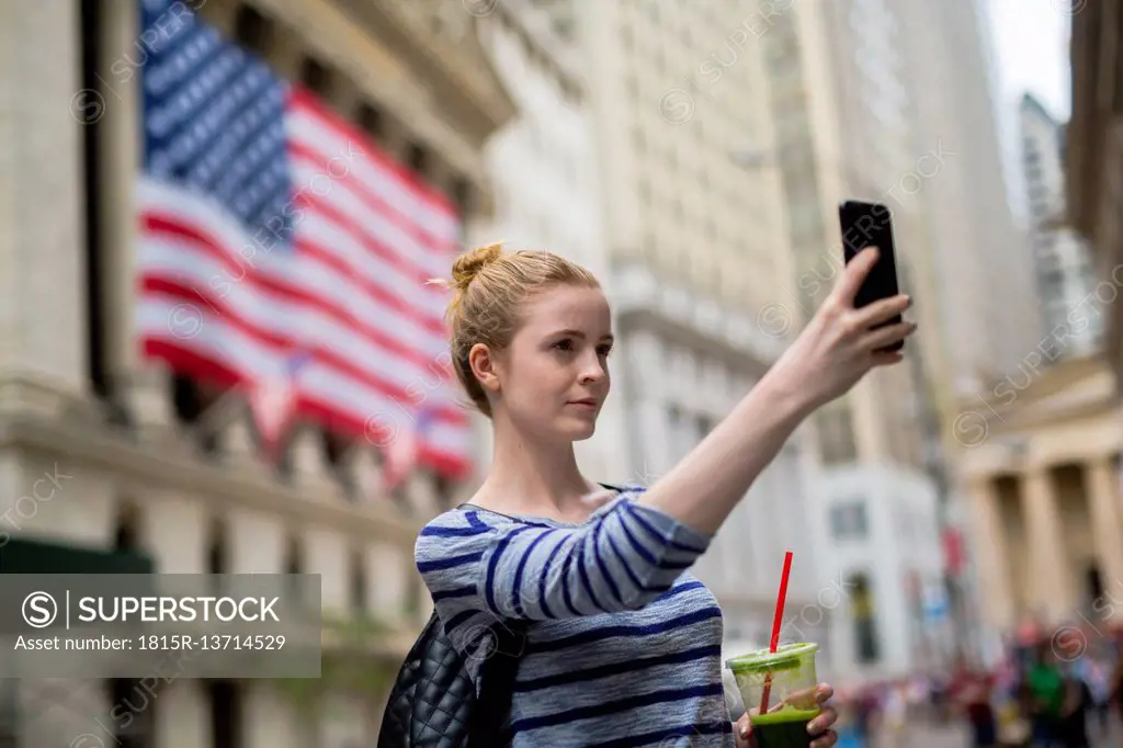 USA, New York City, woman taking selfie in front of New York Stock Exchange