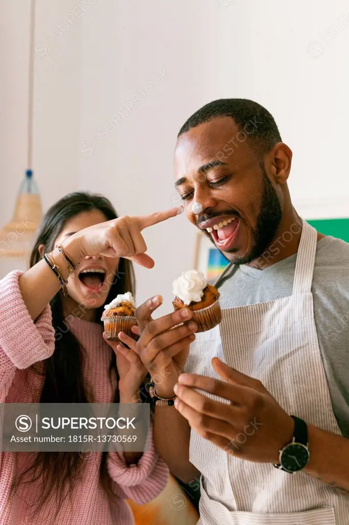 Young couple having fun, eating fresh cupcakes