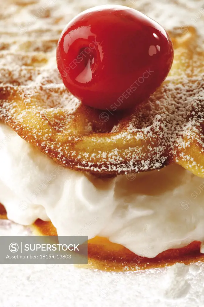Waffle filled with cream, dekorated with cherry, close-up