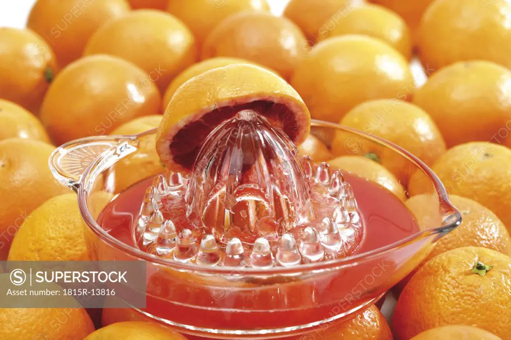 Squeezer with halved blood orange on orange fruits