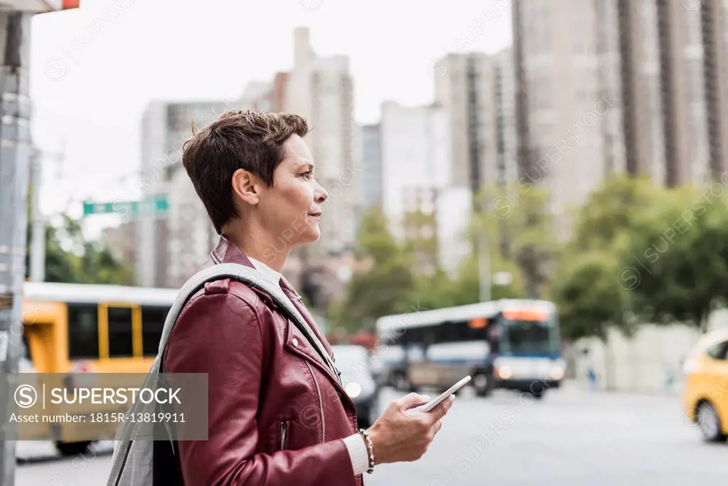 USA, New York City, woman with cell phone in the city