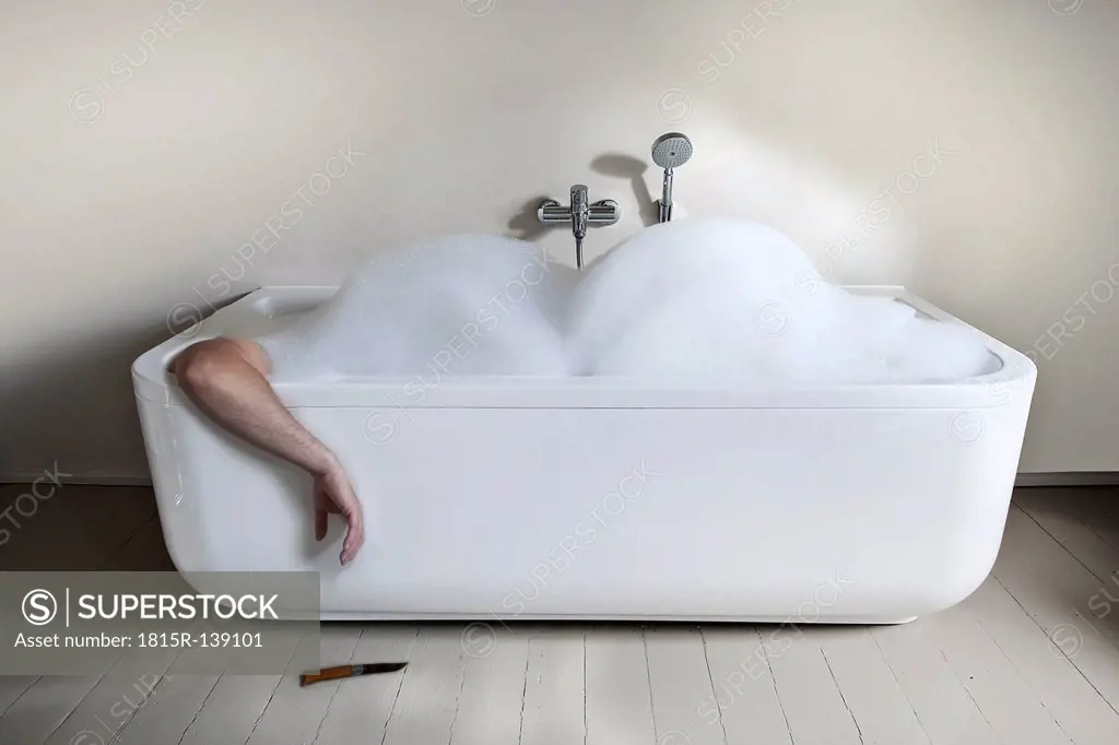 Mid adult man in bathtub with knife