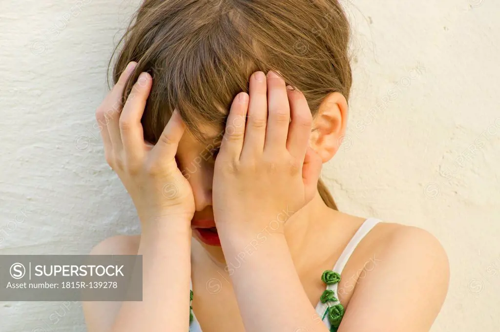 Germany, Baden Wuerttemberg, Girl hiding her face, close up