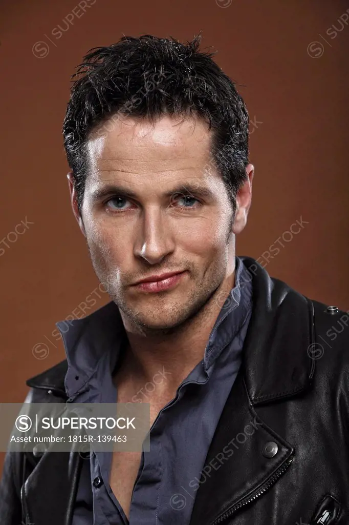 Mid adult man wearing leather jacket, portrait, close up