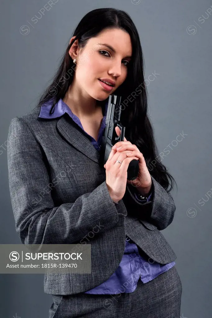 Young woman wearing holding gun, portrait, close up