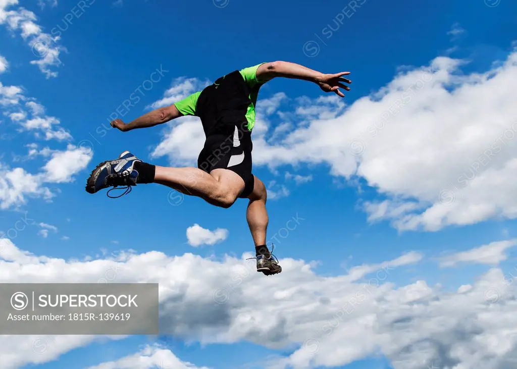 Germany, Mature man doing long jump