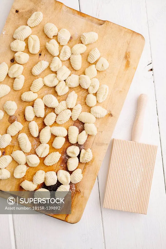 Uncooked gnocchi on chopping board, close up