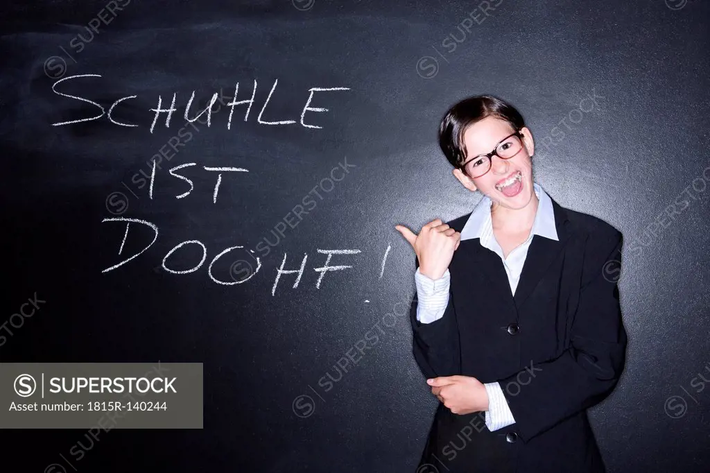 Portrait of girl standing in front of blackboard