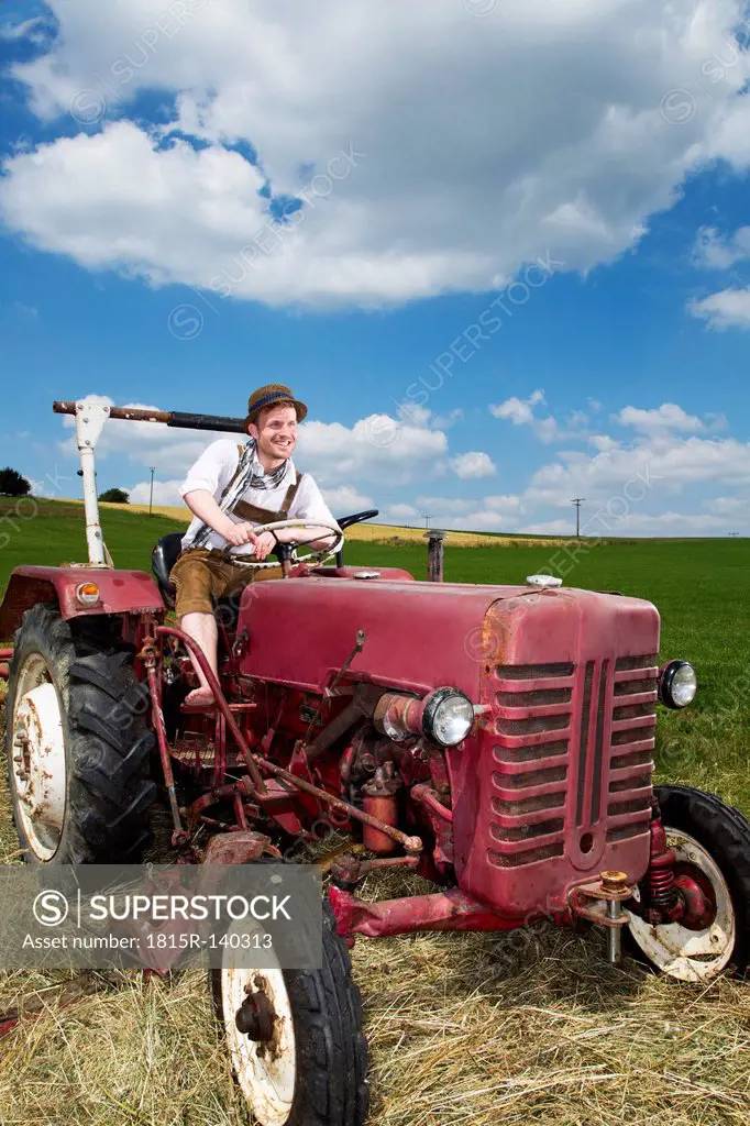 Germany, Bavaria, Farmer in tractor, smiling