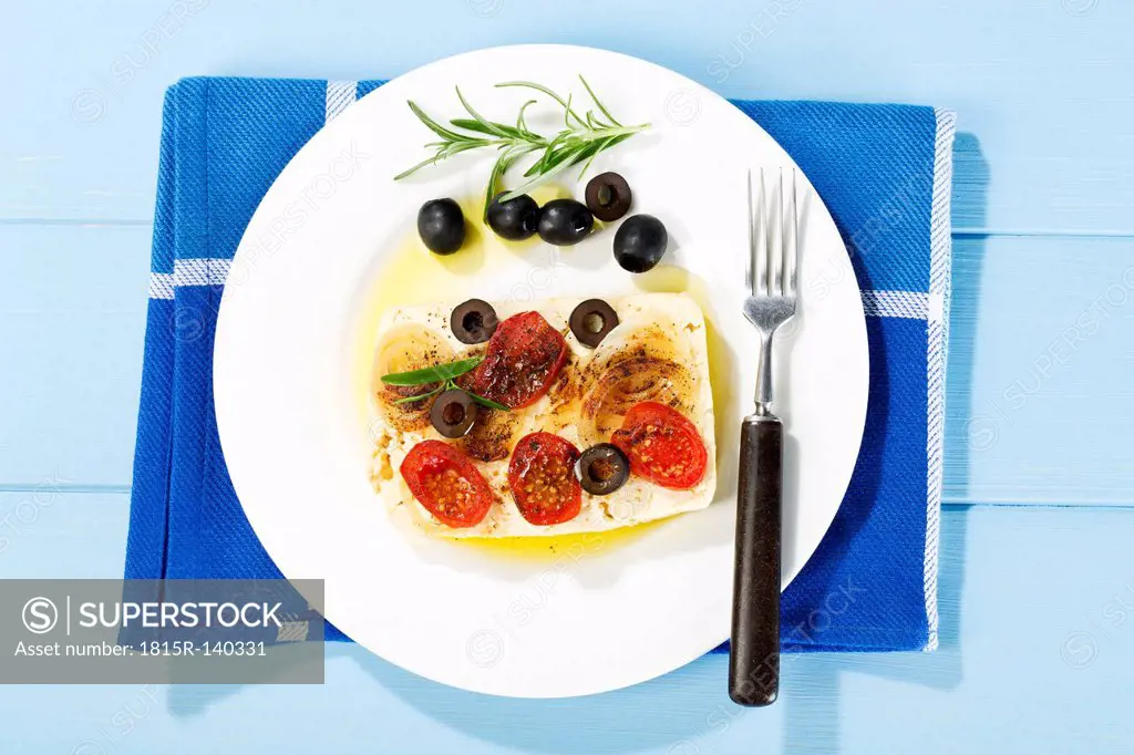 Feta, tomatoes, olives and rosemary in plate with fork