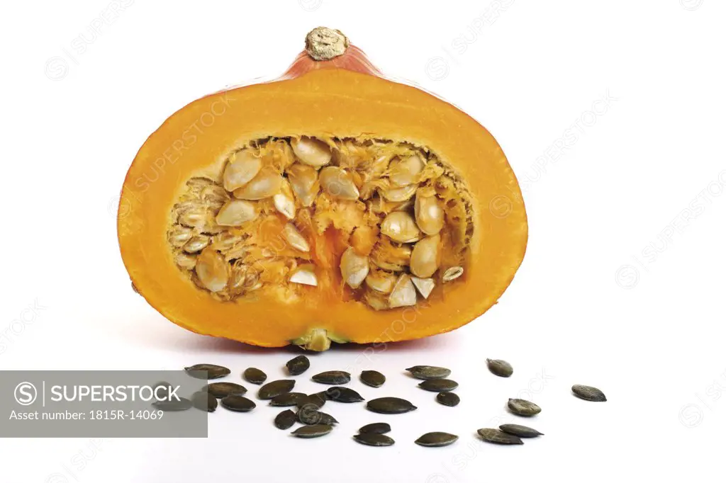 Half a pumpkin, pumpkin seeds in front
