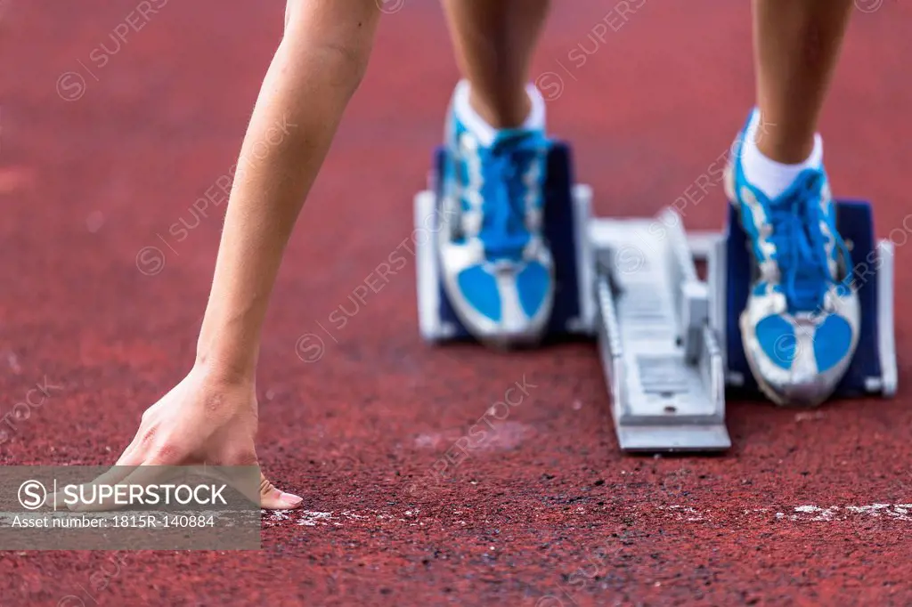 Germany, Young woman running from sprint start