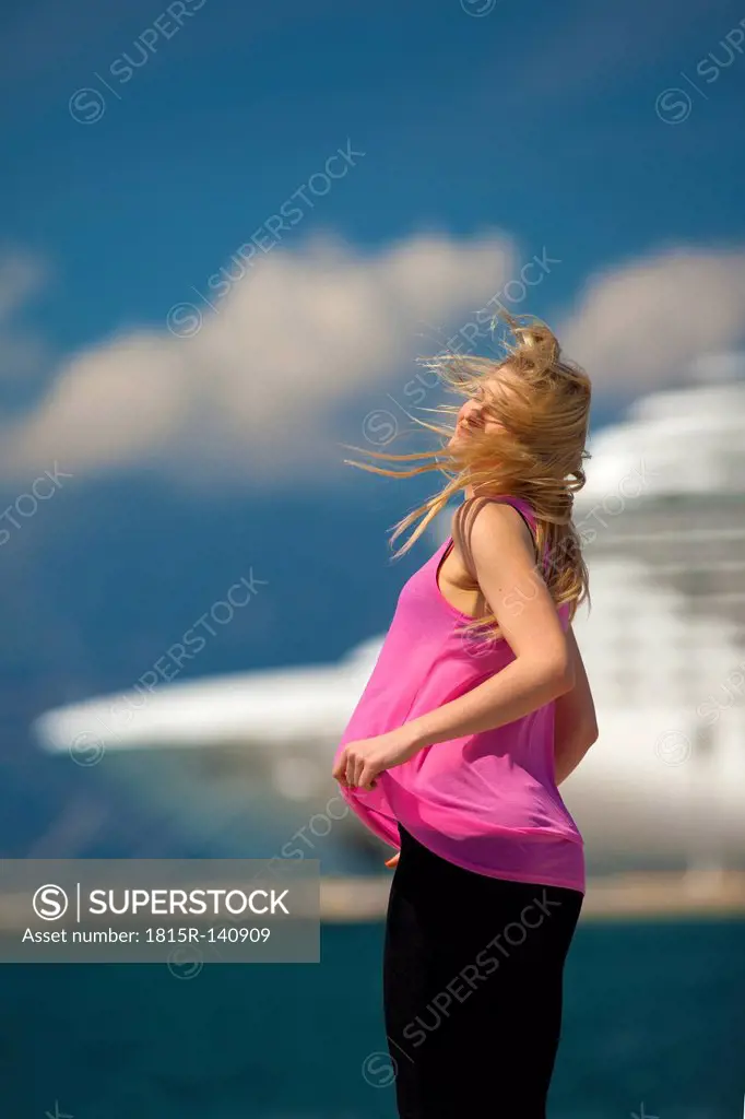 Greece, Young woman posing in front of cruise ship