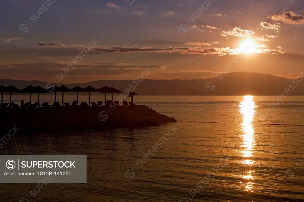 Croatia, Krk, Sunbeds at sunset in Njivice