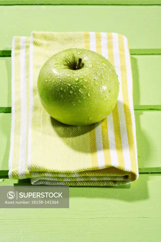 Granny smith with napkin on wodden table, close up
