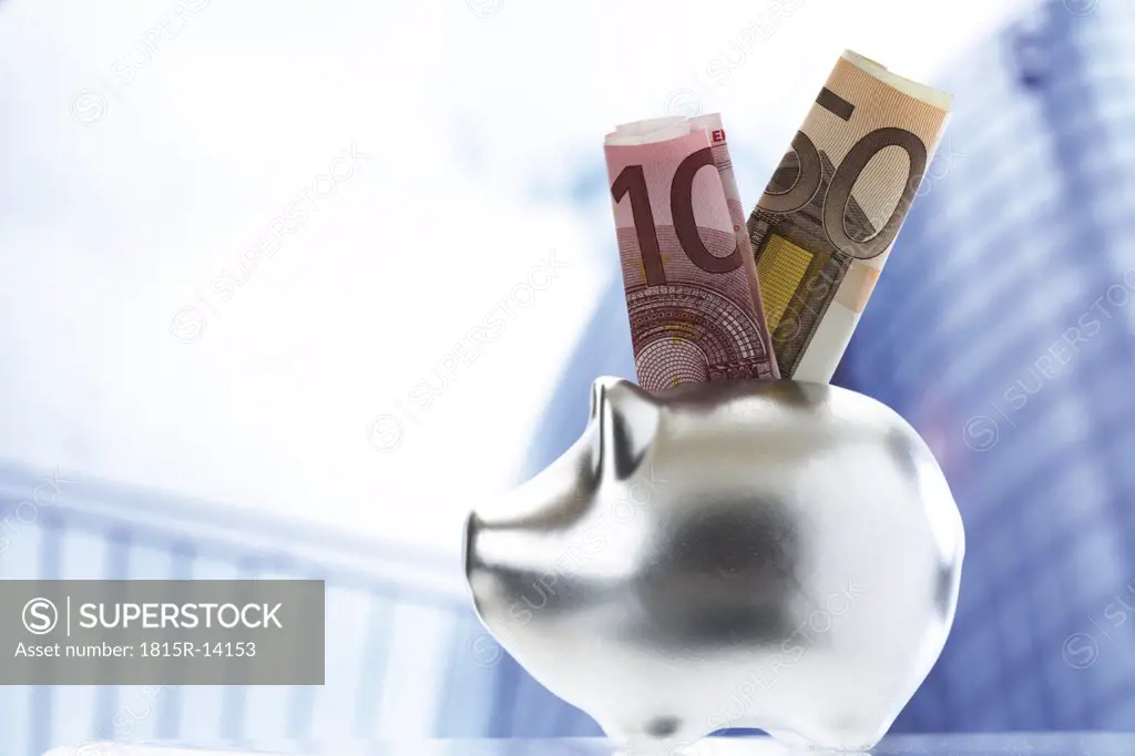 Banknote sticking out of piggy bank slot, close-up