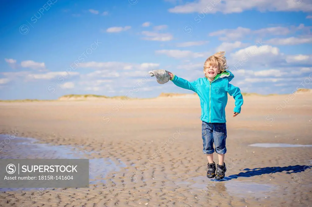 Denmark, Romo, Boy jumping at North Sea, smiling
