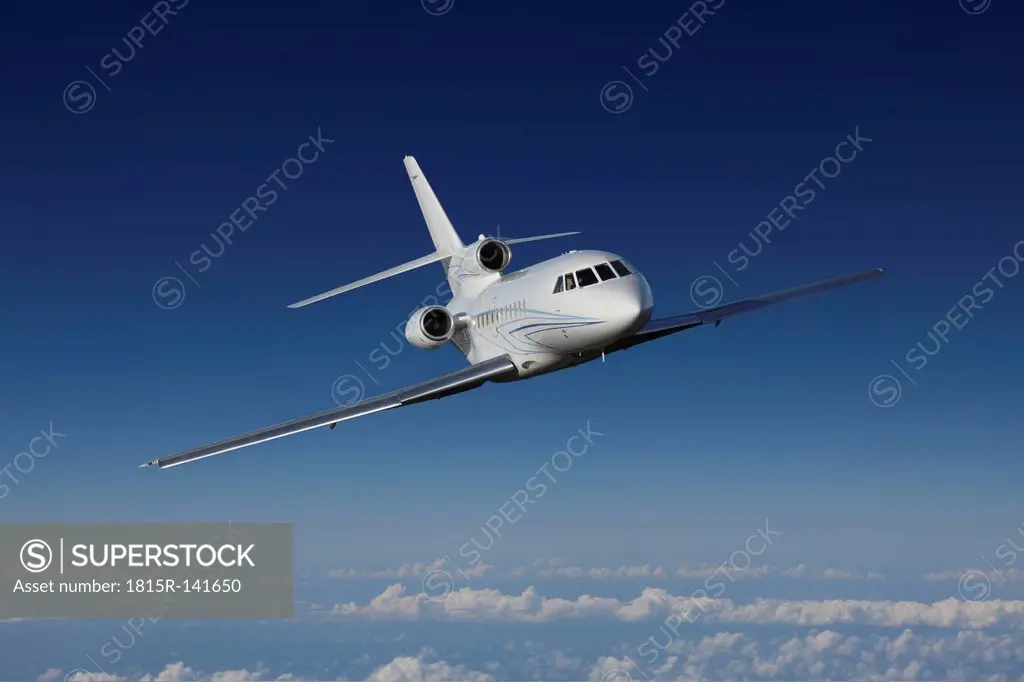 Germany, Bavaria, Munich, Businessjet falcon 900 flying in blue sky