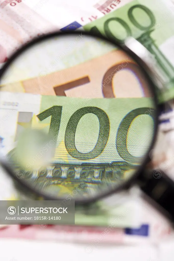 Euro banknotes under magnifying glass, close-up