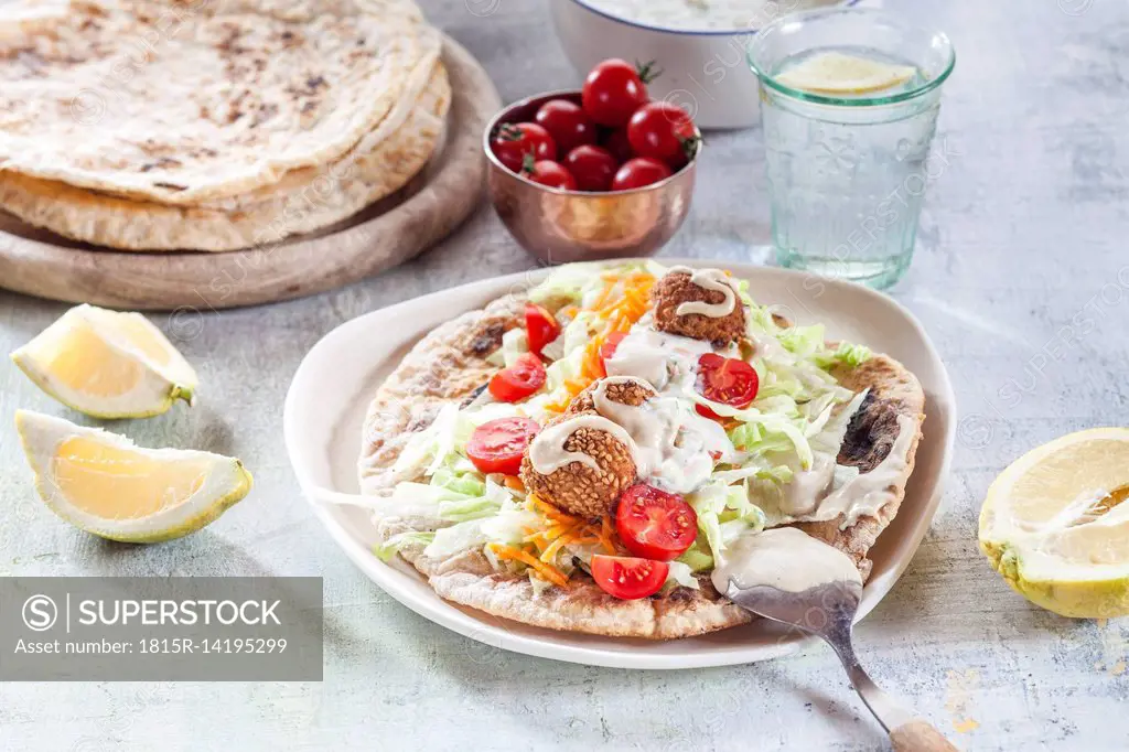 Falafel with salat on homemade flat bread with tahini sauce