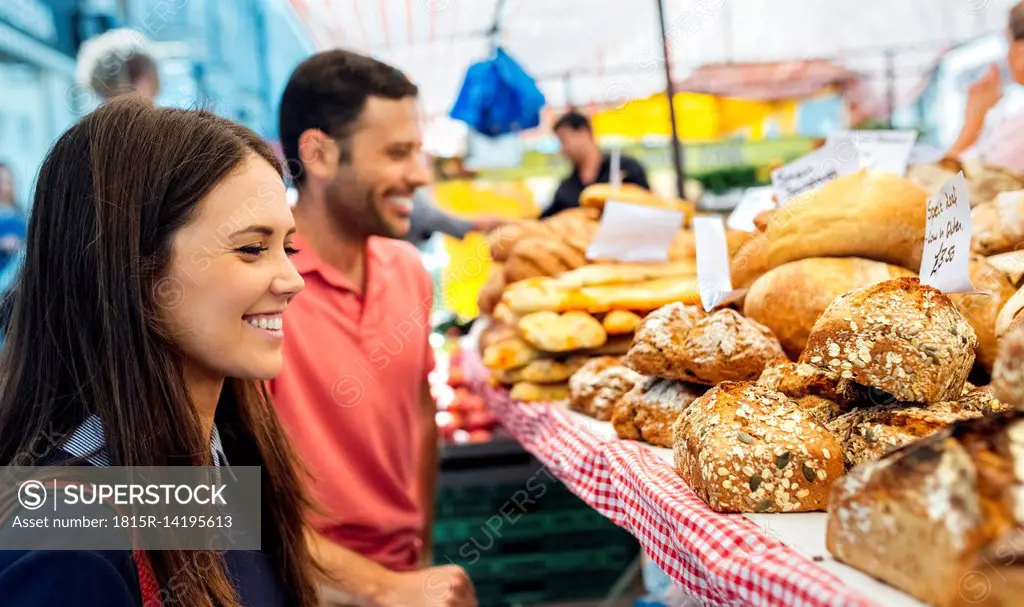 UK, London, Portobello Road, smiling young woman at bread stand