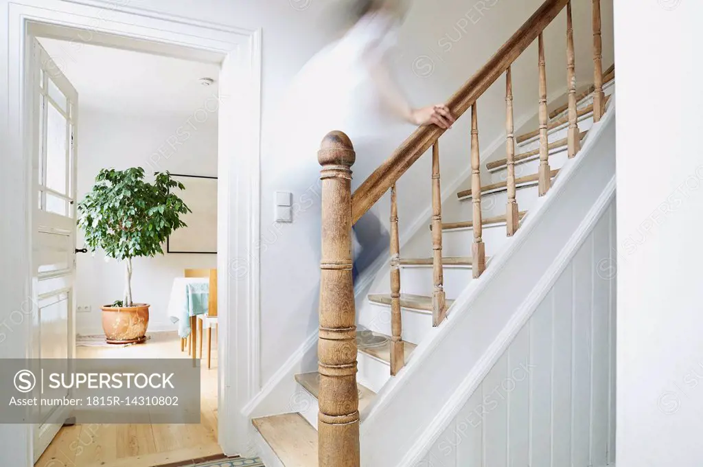 Man going upstairs on wooden stairs in an old country house
