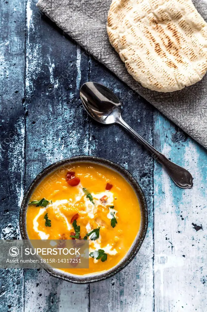 Sweet potato soup in bowl, spoon and bread