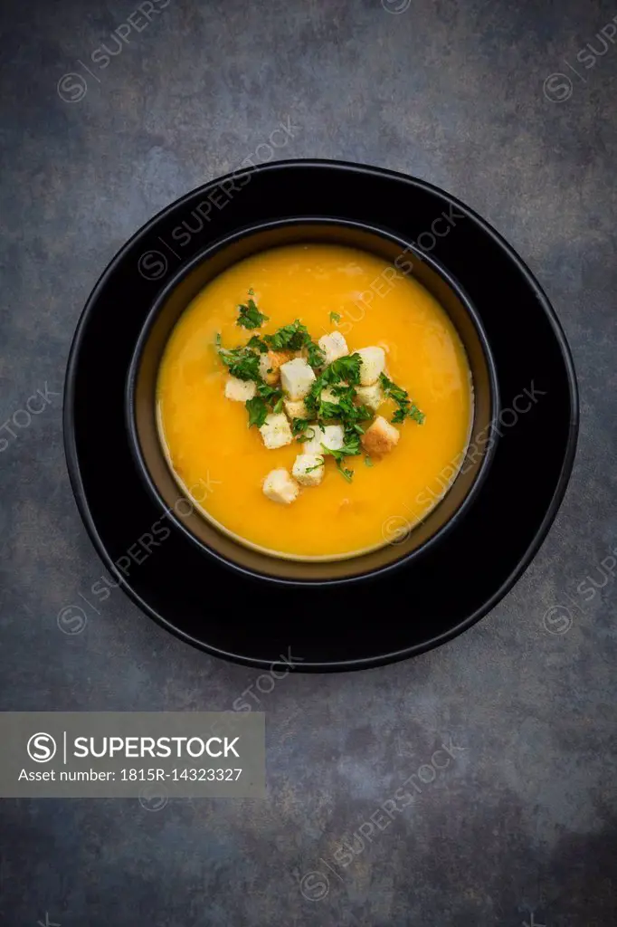 Soup dish of creamed pumpkin soup with croutons and parsley