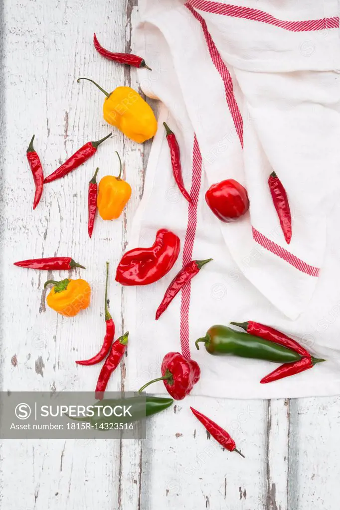 Various chili pods on kitchen towel and wood