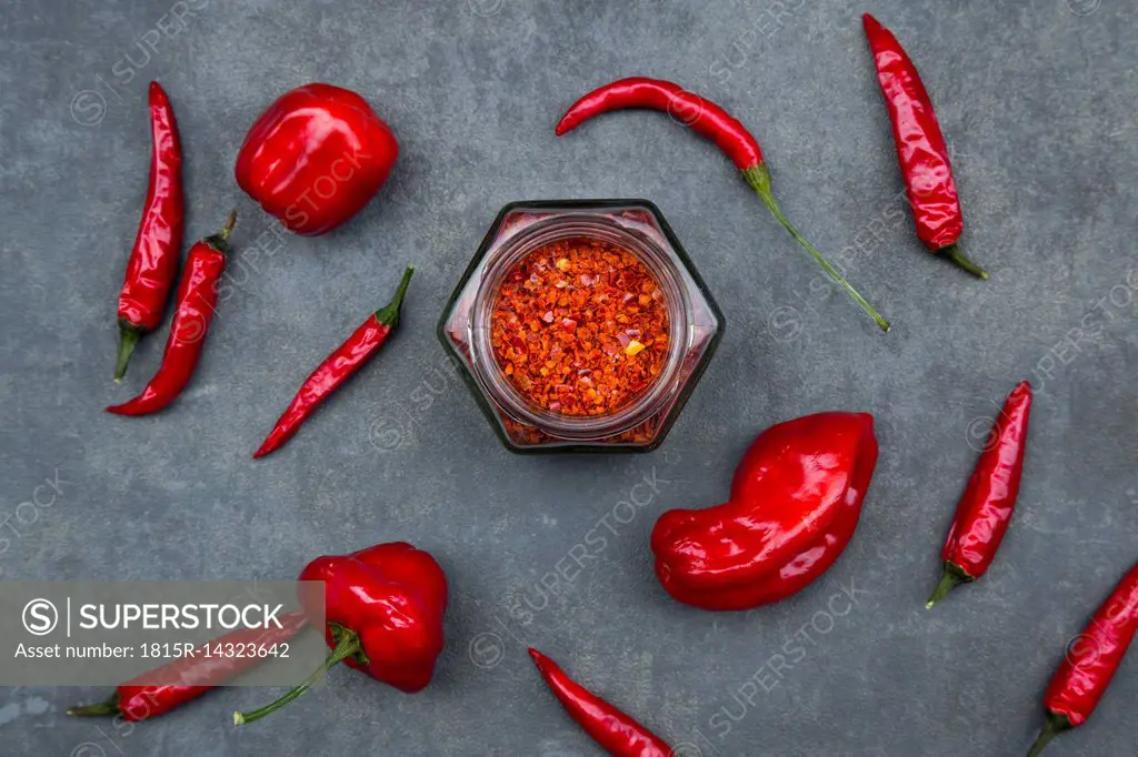 Various red chili pods and glass of chili flakes