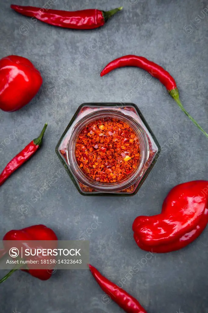 Various red chili pods and glass of chili flakes