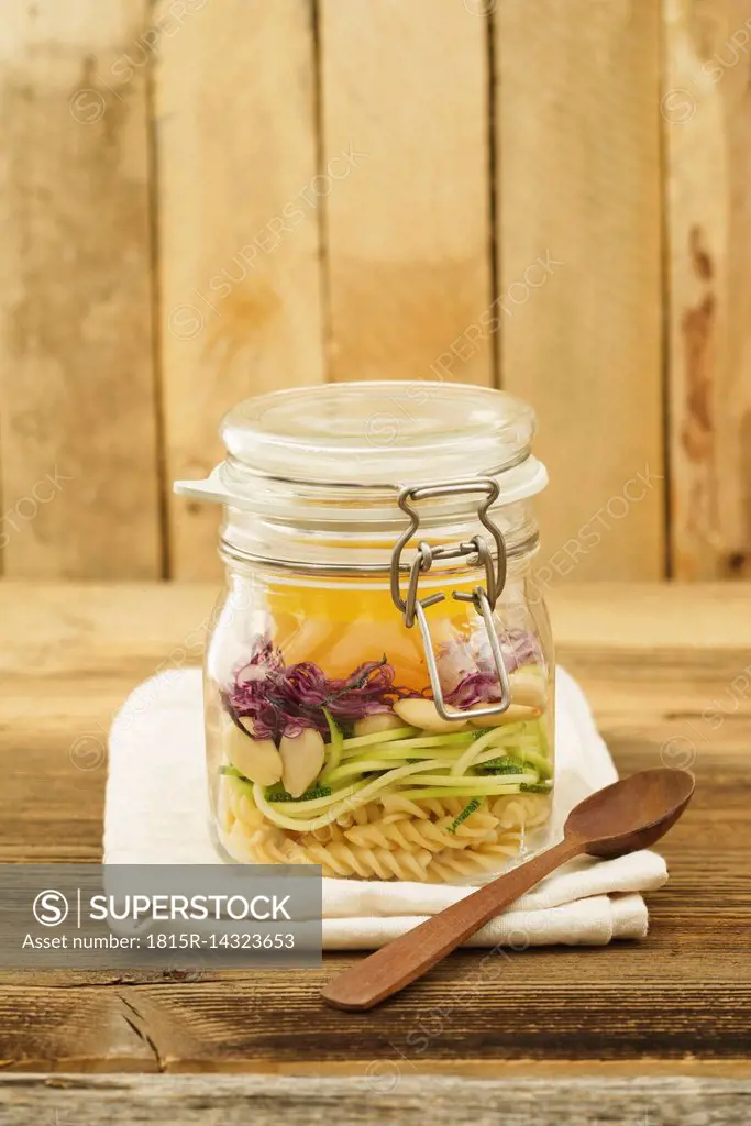 Preserving jar of vegan mixed salad with pasta