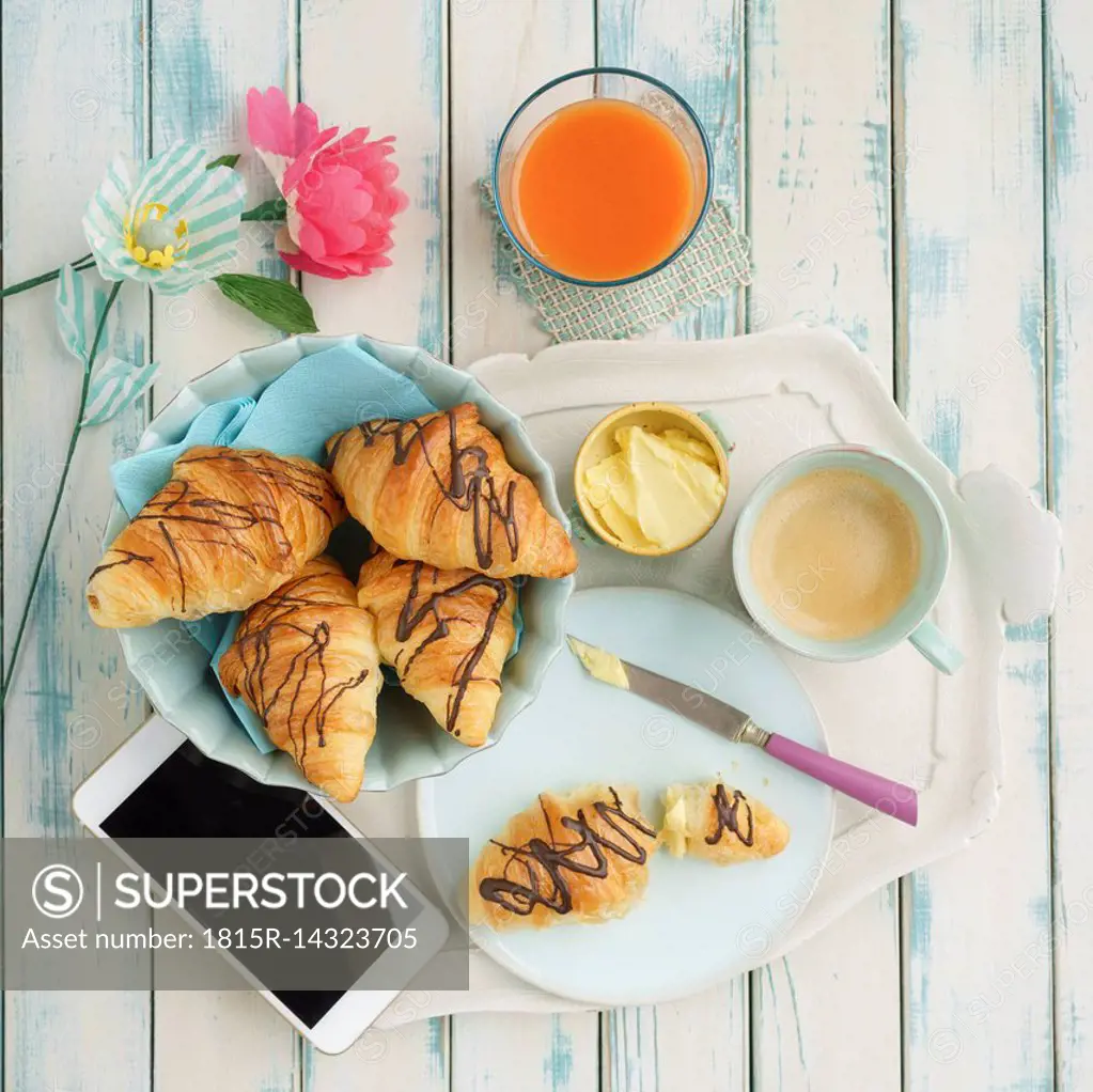 Breakfast with chocolate croissants and smartphone