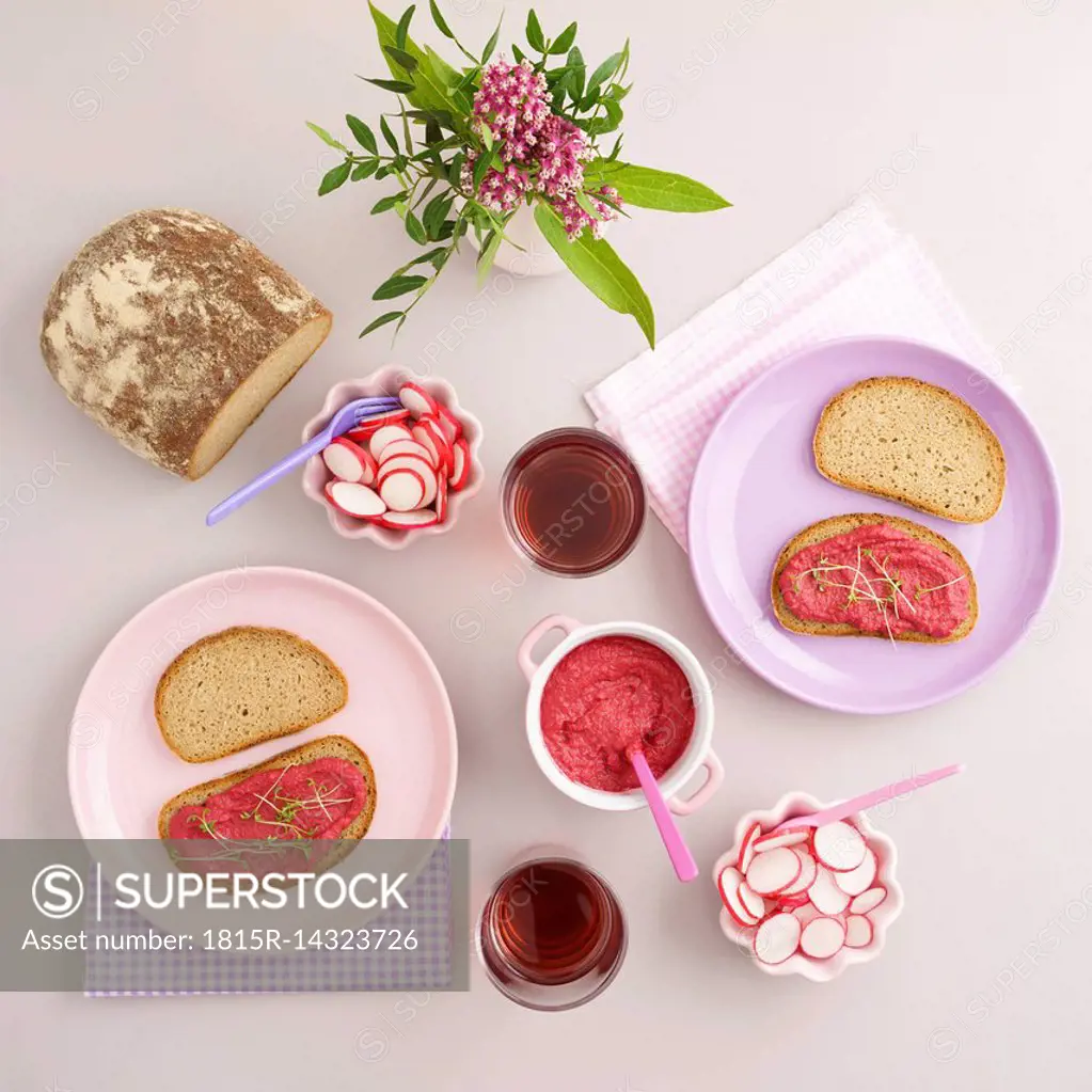Vegan supper with bread, beetroot spread, red radish and juice
