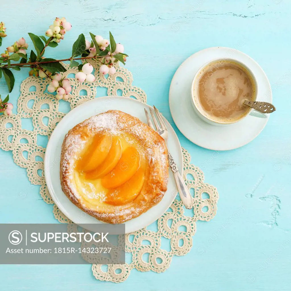 Flowers, coffee and Danish pastry with peaches and custard