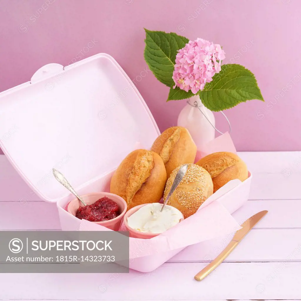 Lunch box with bread rolls, jam and cream cheese