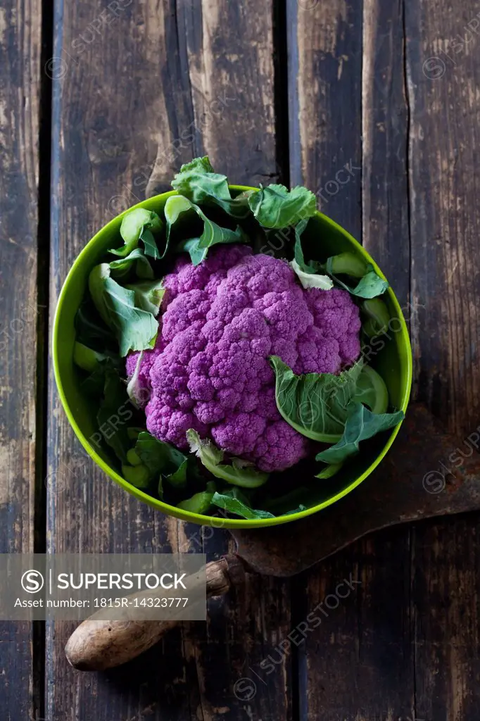 Purple cauliflower in a bowl on wood