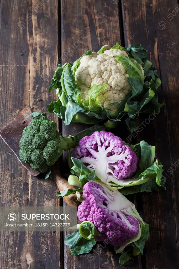 Purple and white cauliflower and broccoli on dark wood