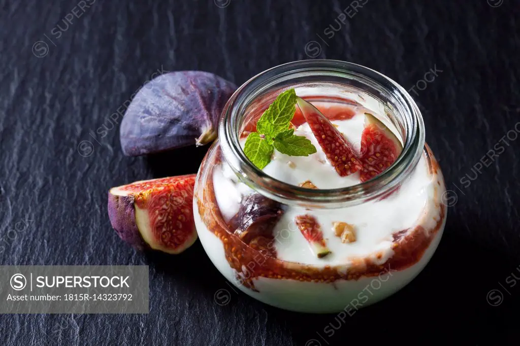 Glass of Mascarpone cream with fig compote and walnuts on slate