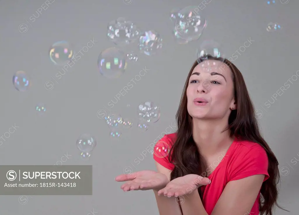 Young woman playing with bubbles, close up