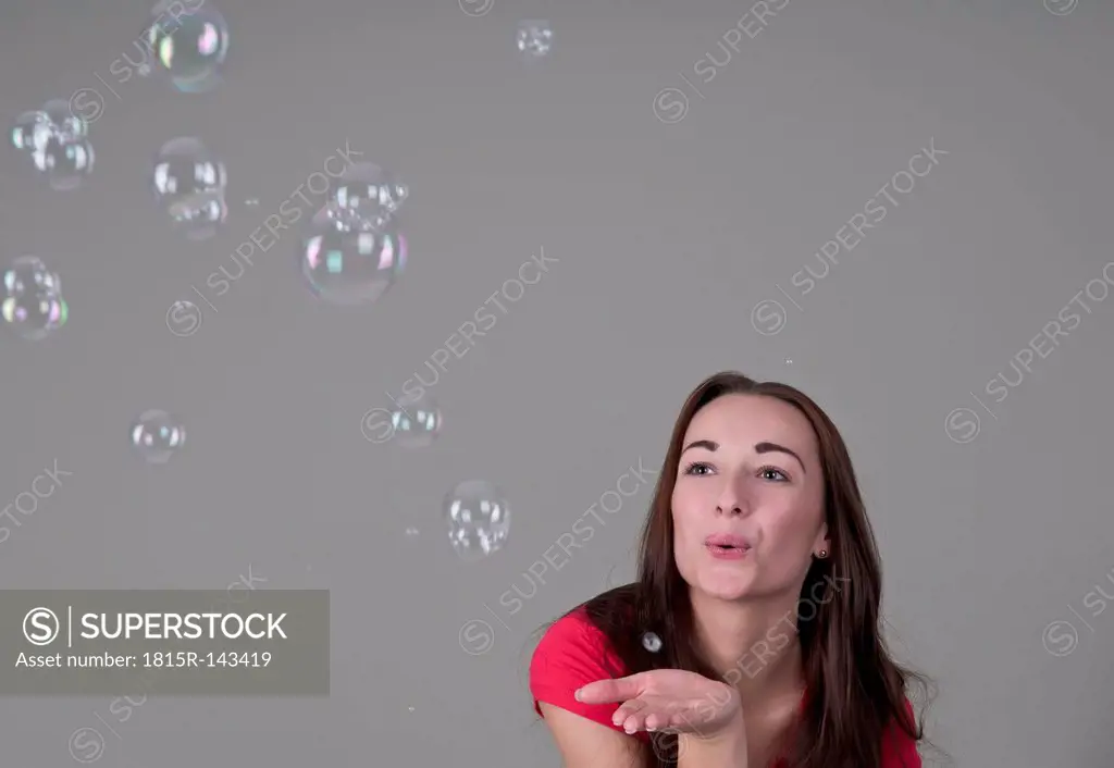 Young woman playing with bubbles, close up